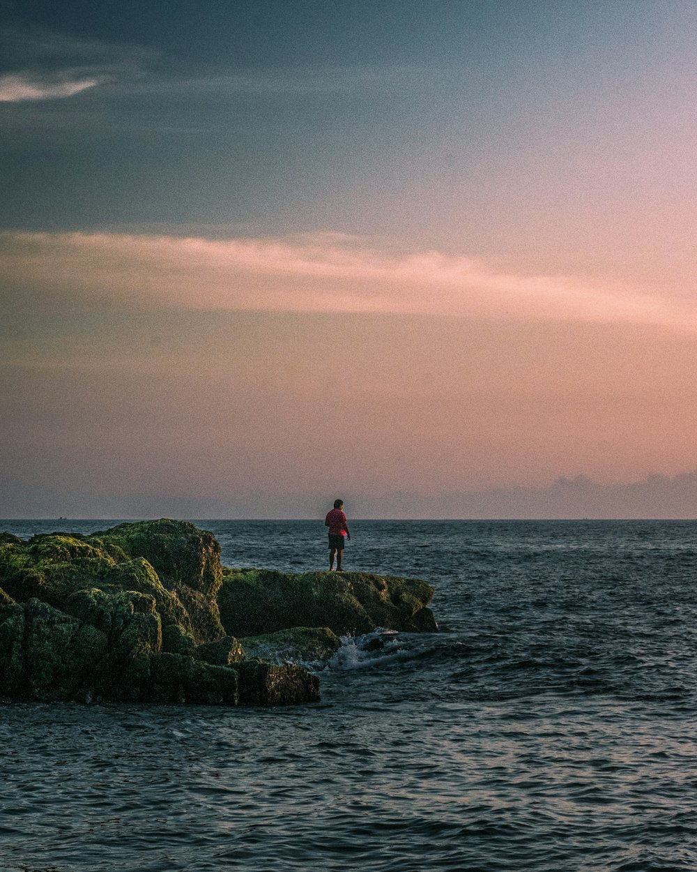 a person standing on a rock in the water