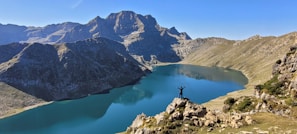 a person standing on a rock in a lake