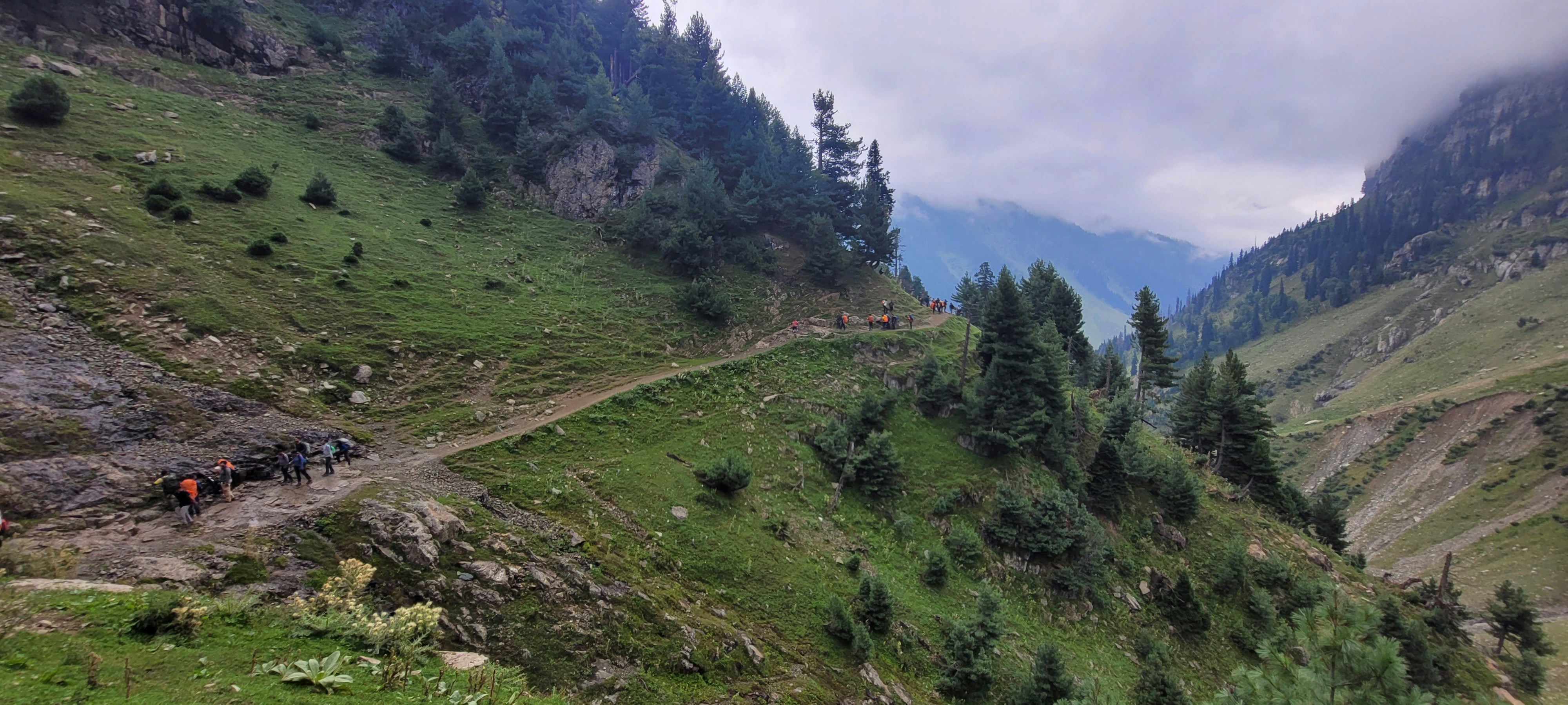a group of people walking on a trail in a valley