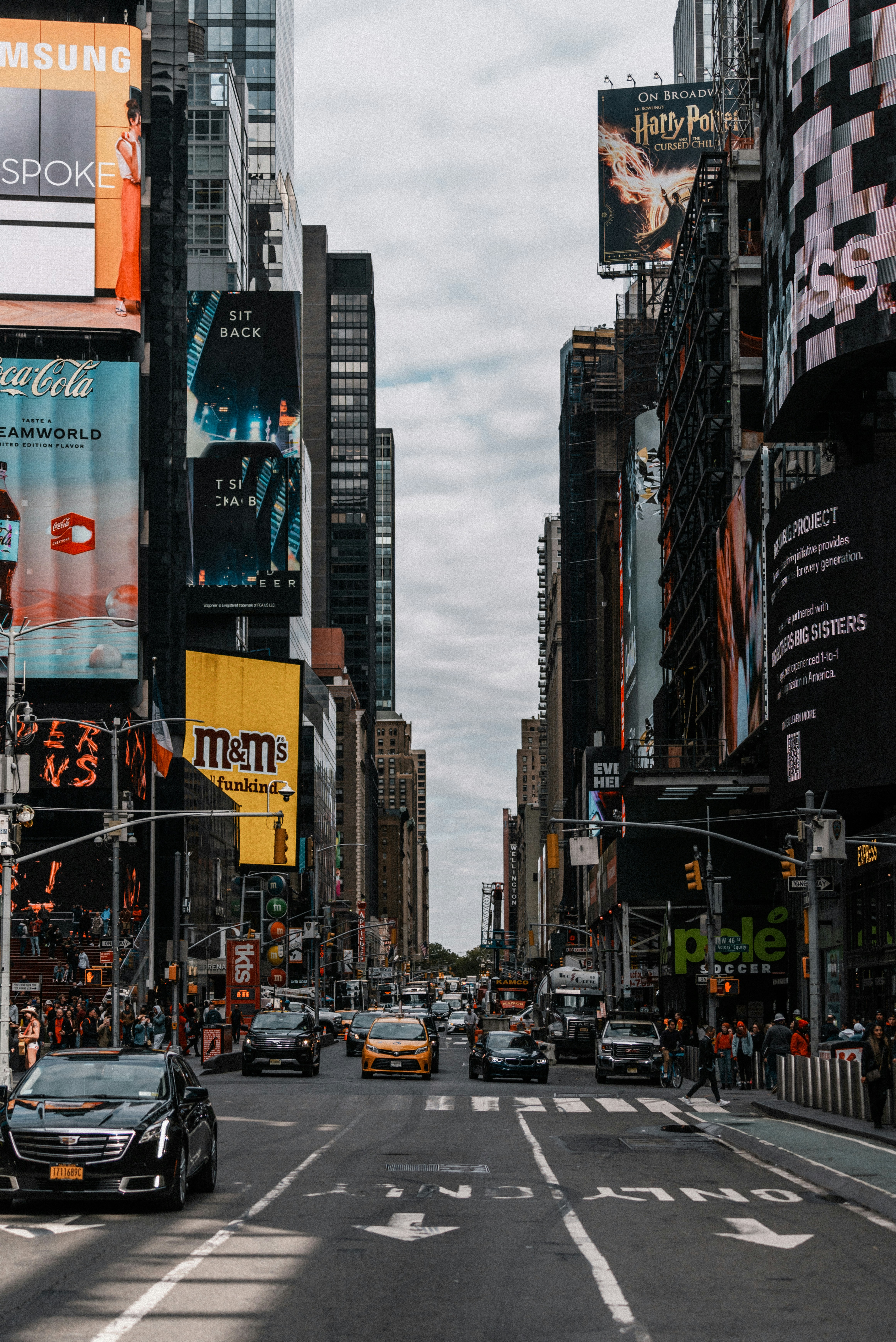 a busy city street with Times Square in the background