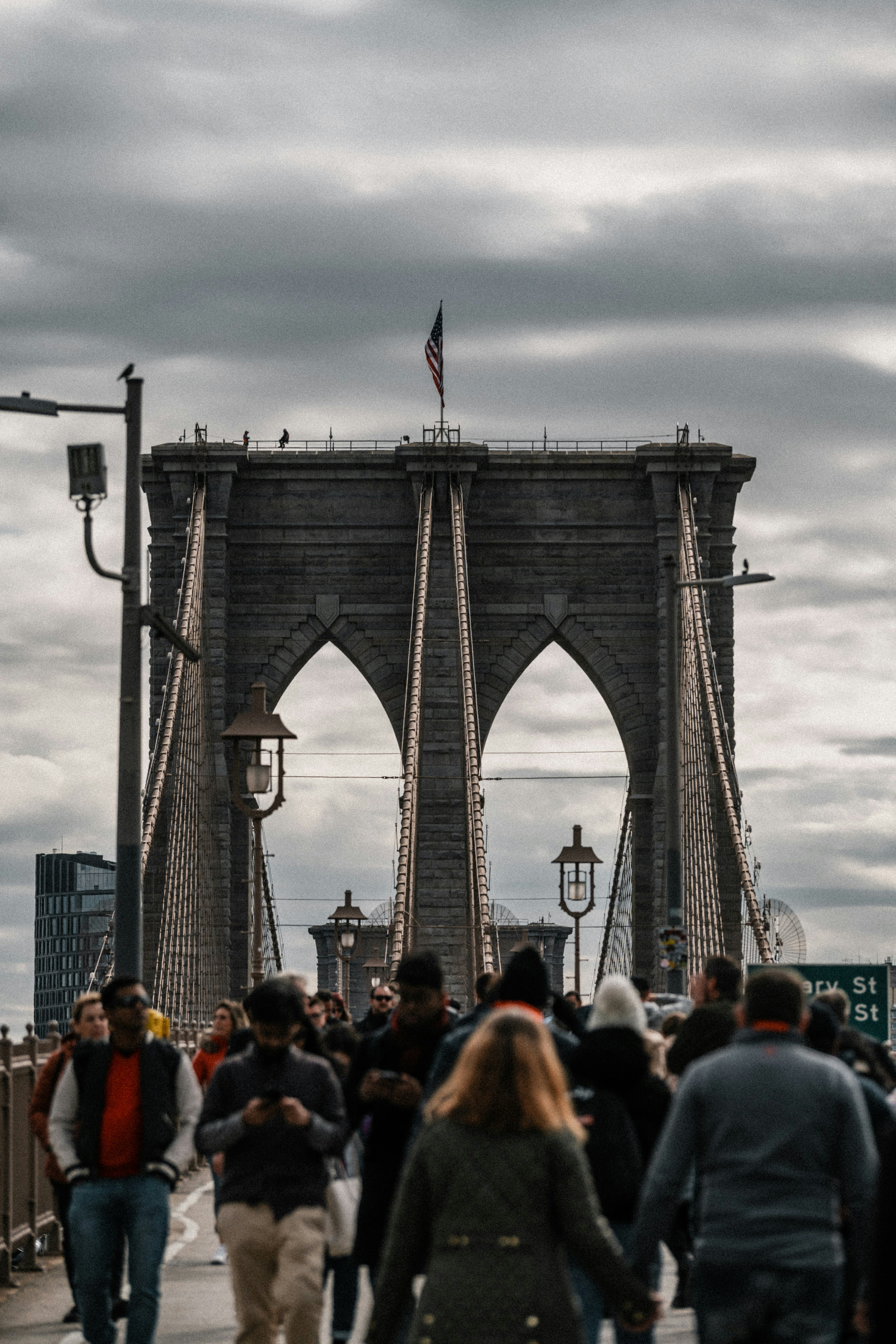 a group of people walking on a sidewalk next to a large monument