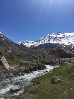 A scenic mountain landscape with a winding river under a clear blue sky.