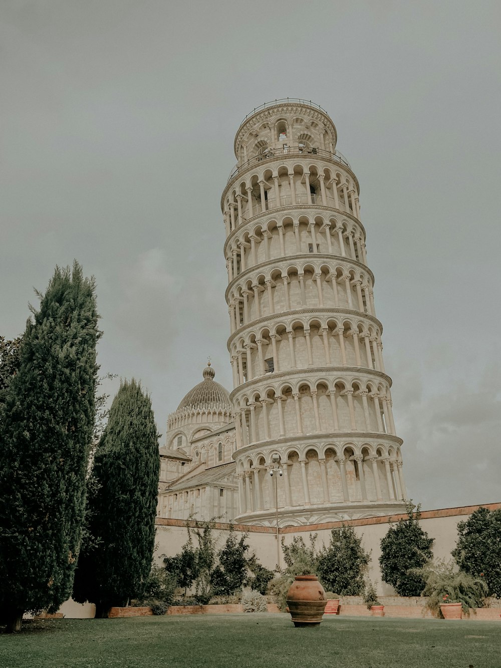 a tall white tower with Leaning Tower of Pisa in the background