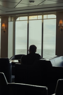 A calm young man sitting peacefully in a cozy room with soft natural light.