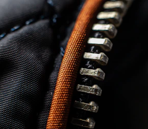 a close up of a black and orange zippered zipper