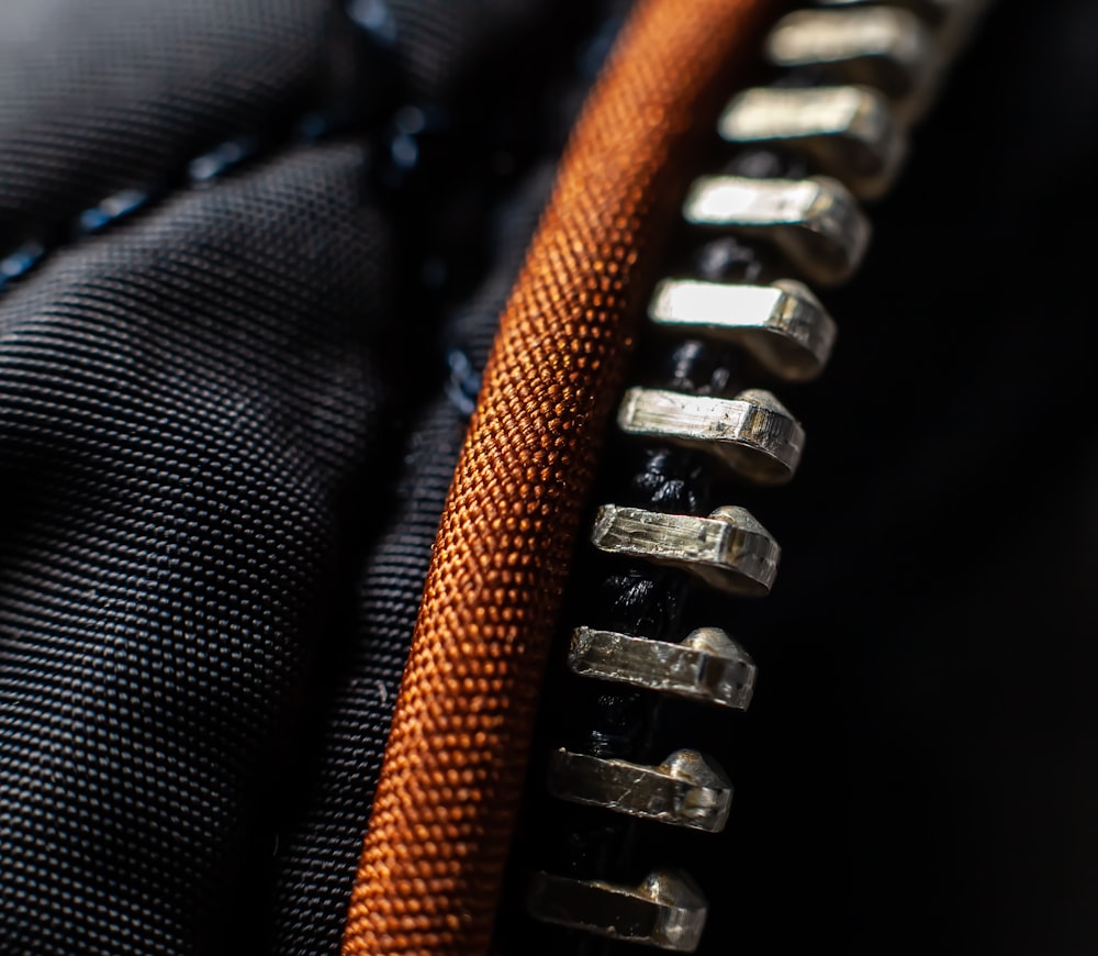 a close up of a black and orange zippered zipper