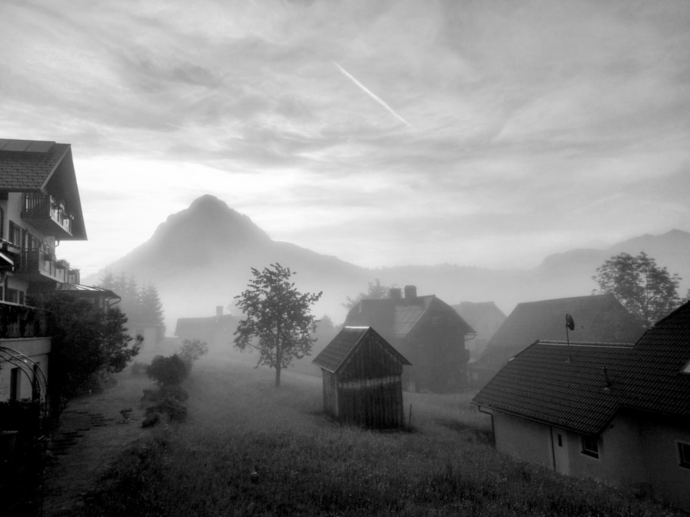 a group of houses with a trail of smoke in the sky