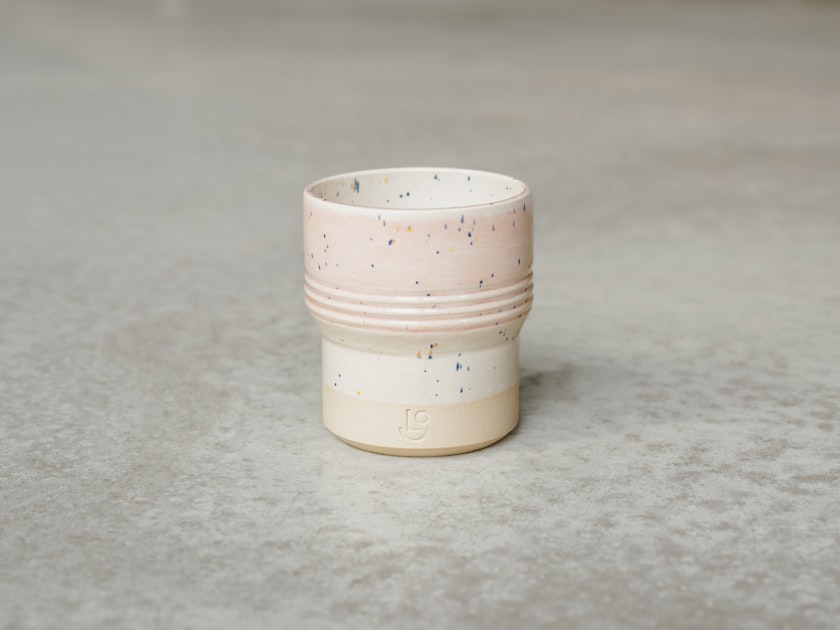 a white cup on a grey surface