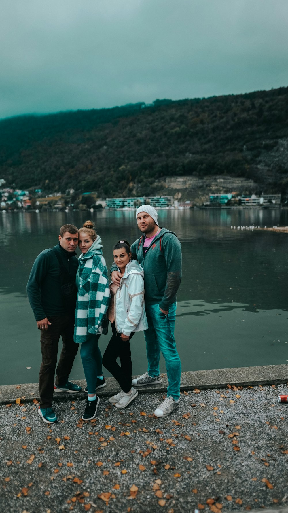 a group of people posing for a photo by a body of water