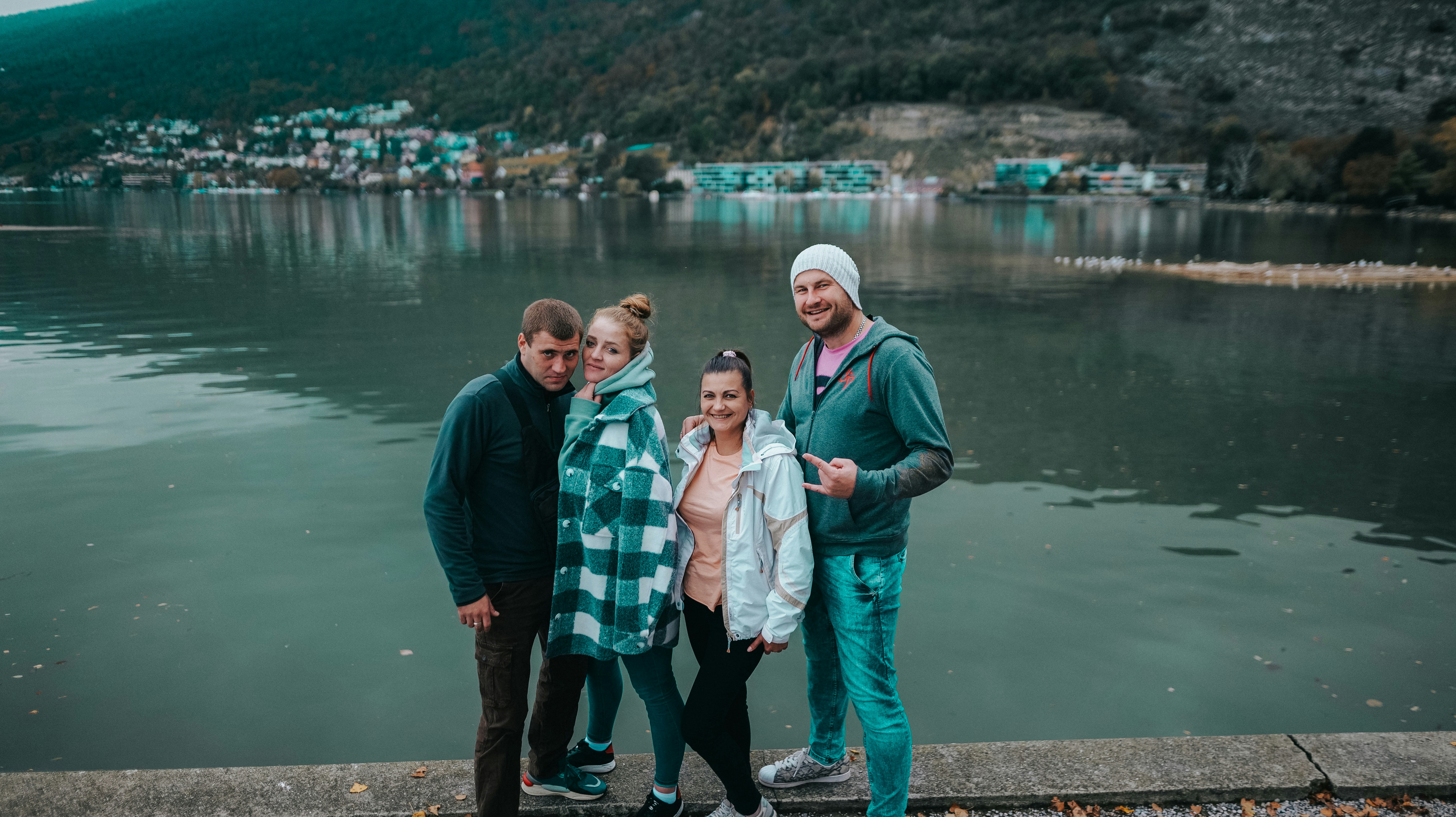 a group of people posing for a photo by a body of water