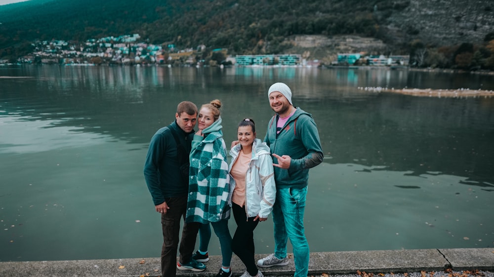a group of people posing for a photo by a body of water