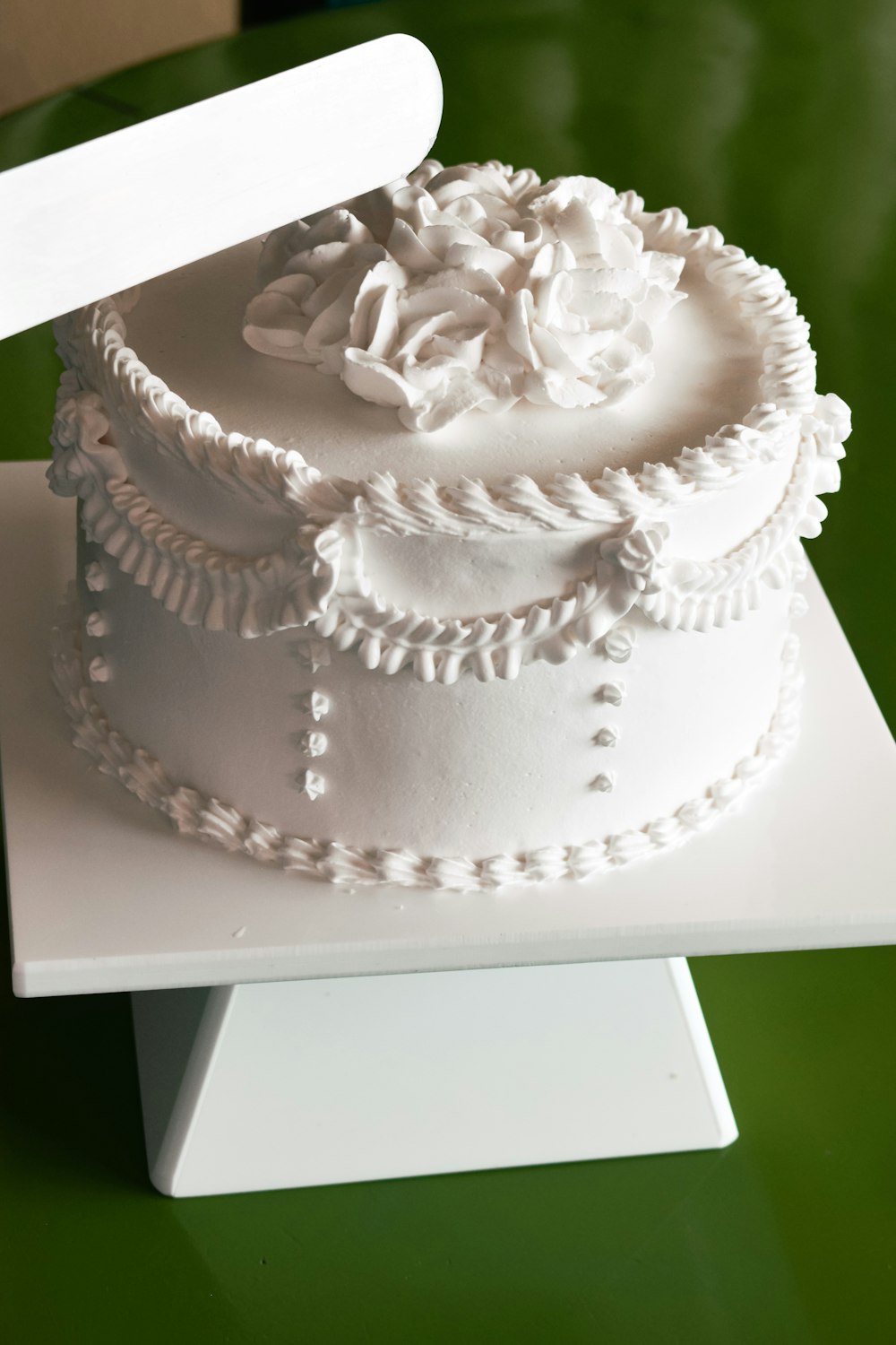 a white cake with a white frosting and a knife on top