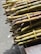 Bundles of green and brown sugarcane stalks are tied together with yellow twine, resting on a wooden surface. The stalks are neatly cut and highlighted by natural sunlight.