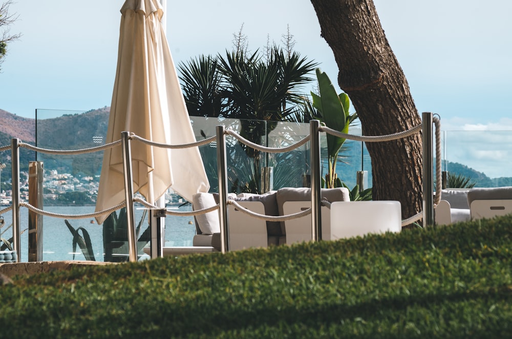 a lounge chair and umbrella on a lawn