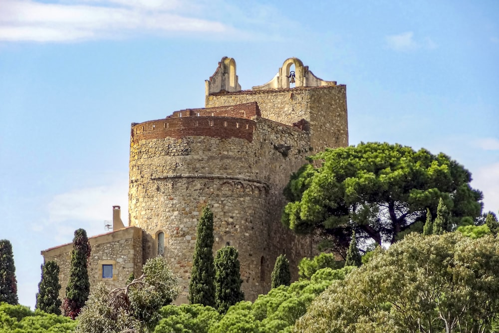 a stone castle with trees in front of it