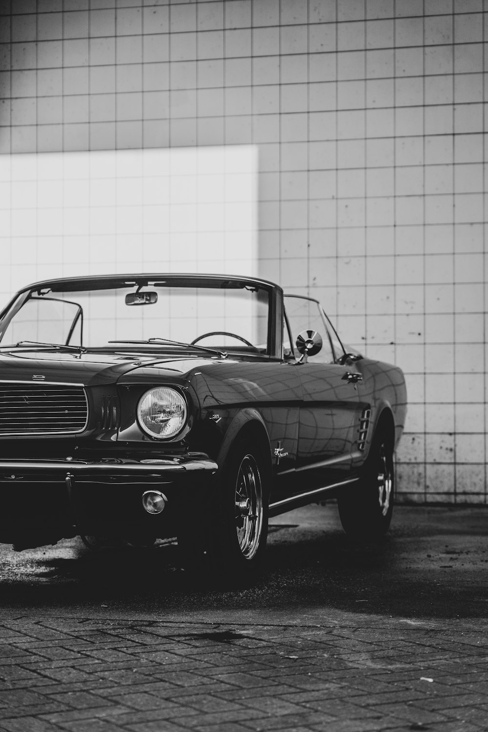 a black car parked in front of a white wall