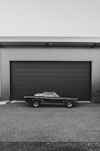 a black car parked in front of a garage