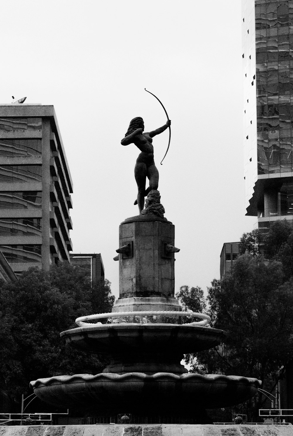 a statue of a person holding a spear in a fountain