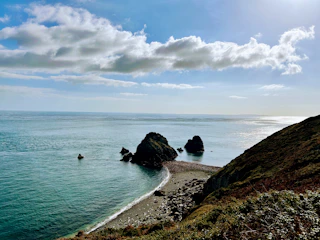 a rocky beach with a body of water in the background