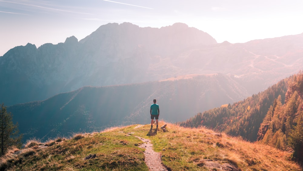 a man and a dog on a trail in a mountainous region