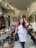 A cheerful restaurant owner standing in front of a beautifully styled dining area.