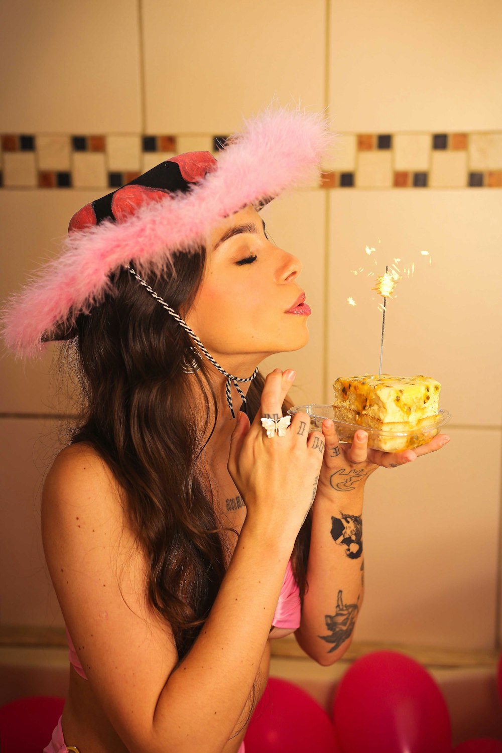 a woman wearing a pink wig and holding a cupcake