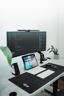 a desk with a computer and a laptop on it