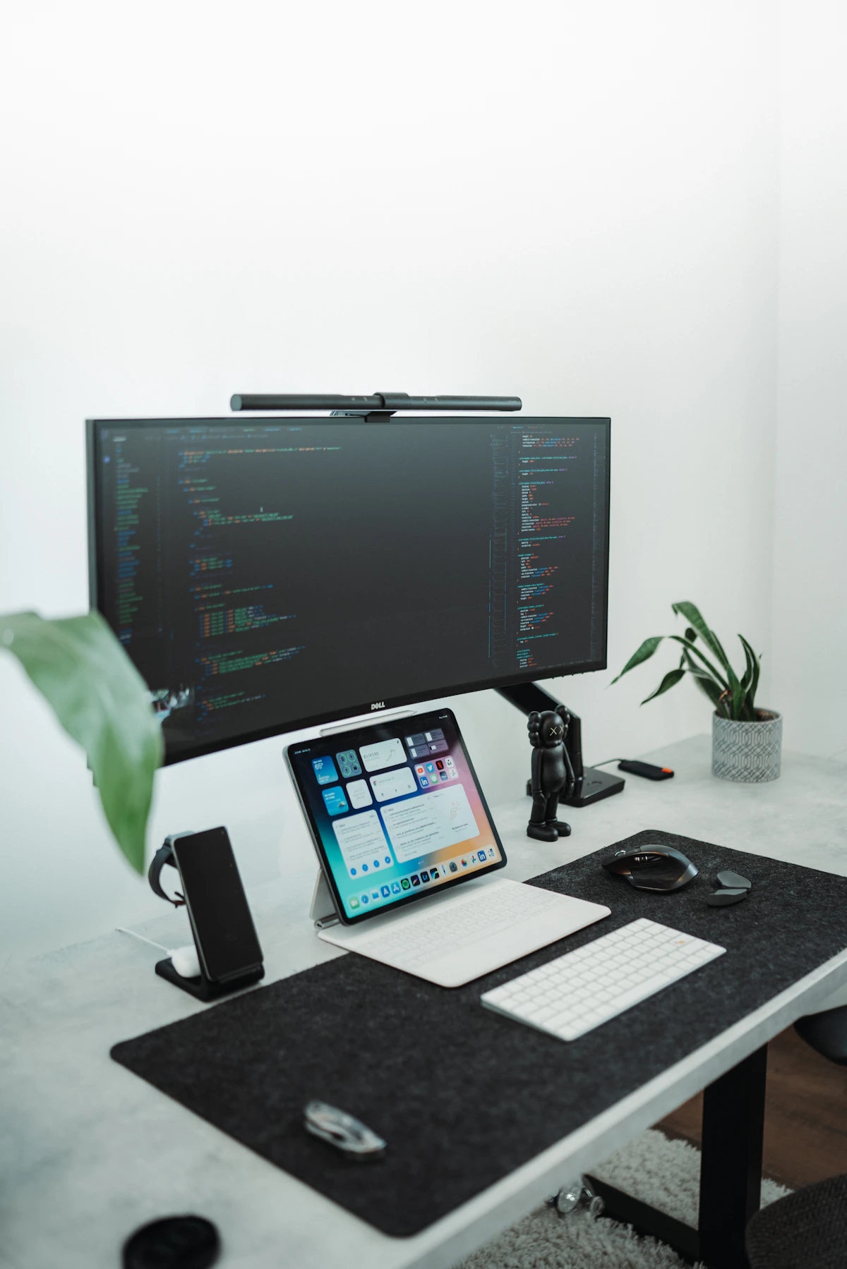 A clean desktop workspace with a large monitor and tablet