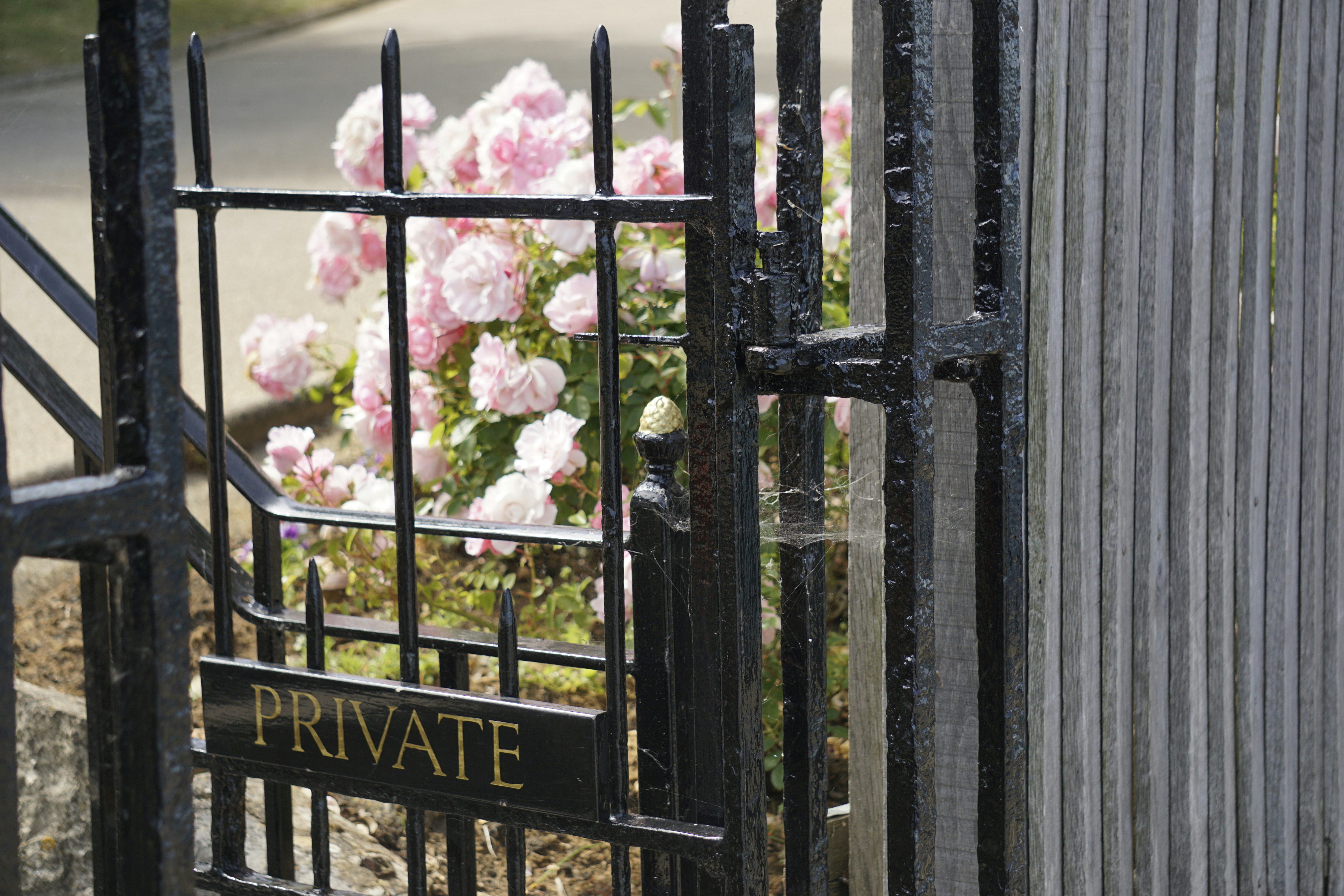 a gate with private written on it with pink flowers