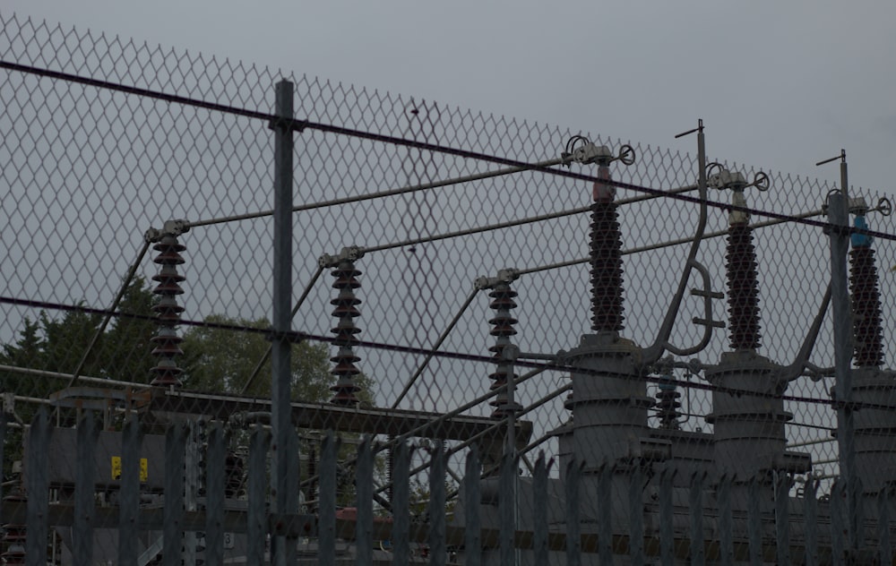 a fence with a metal gate and trees in the background