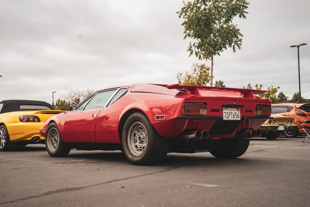 a red car parked next to other cars