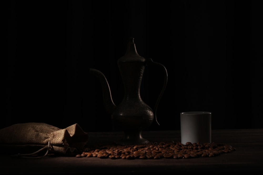 a cup of coffee and a pitcher of coffee on a table