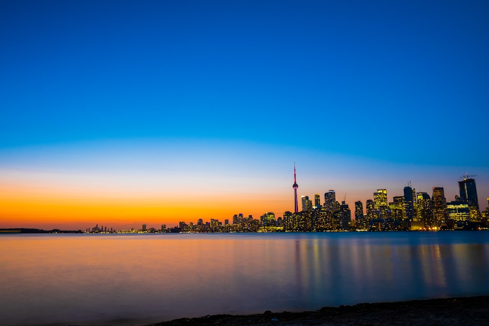 a city skyline with a body of water in the foreground