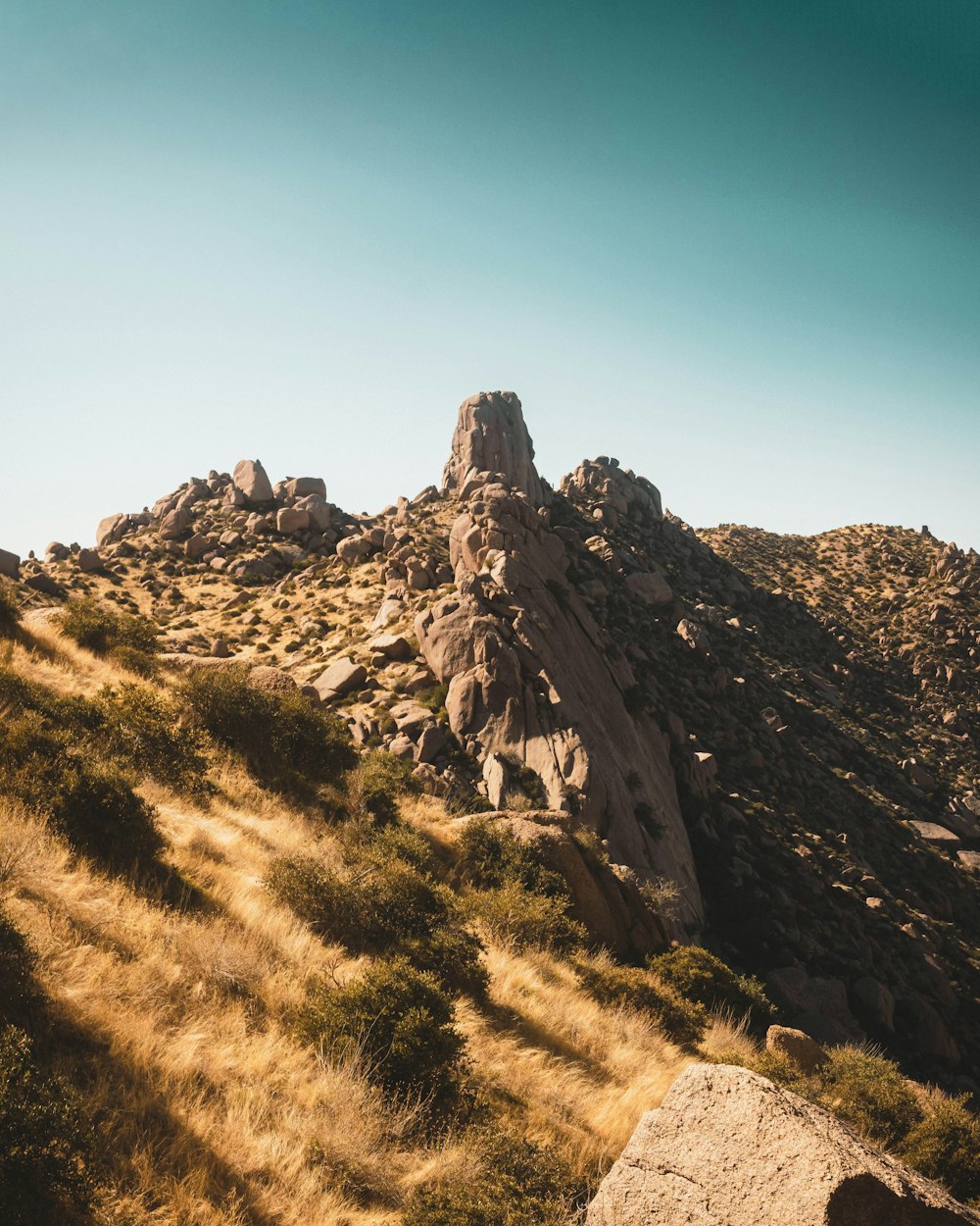 a rocky mountain with a blue sky