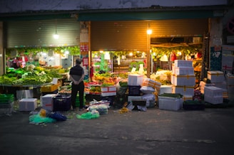 a person standing in front of a fruit stand