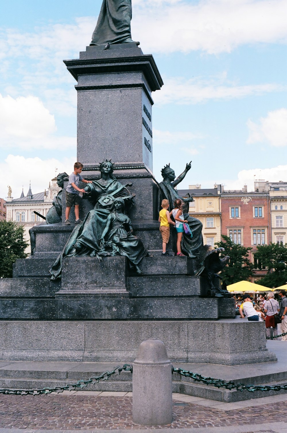 a statue of a man and a woman standing on a stone pedestal