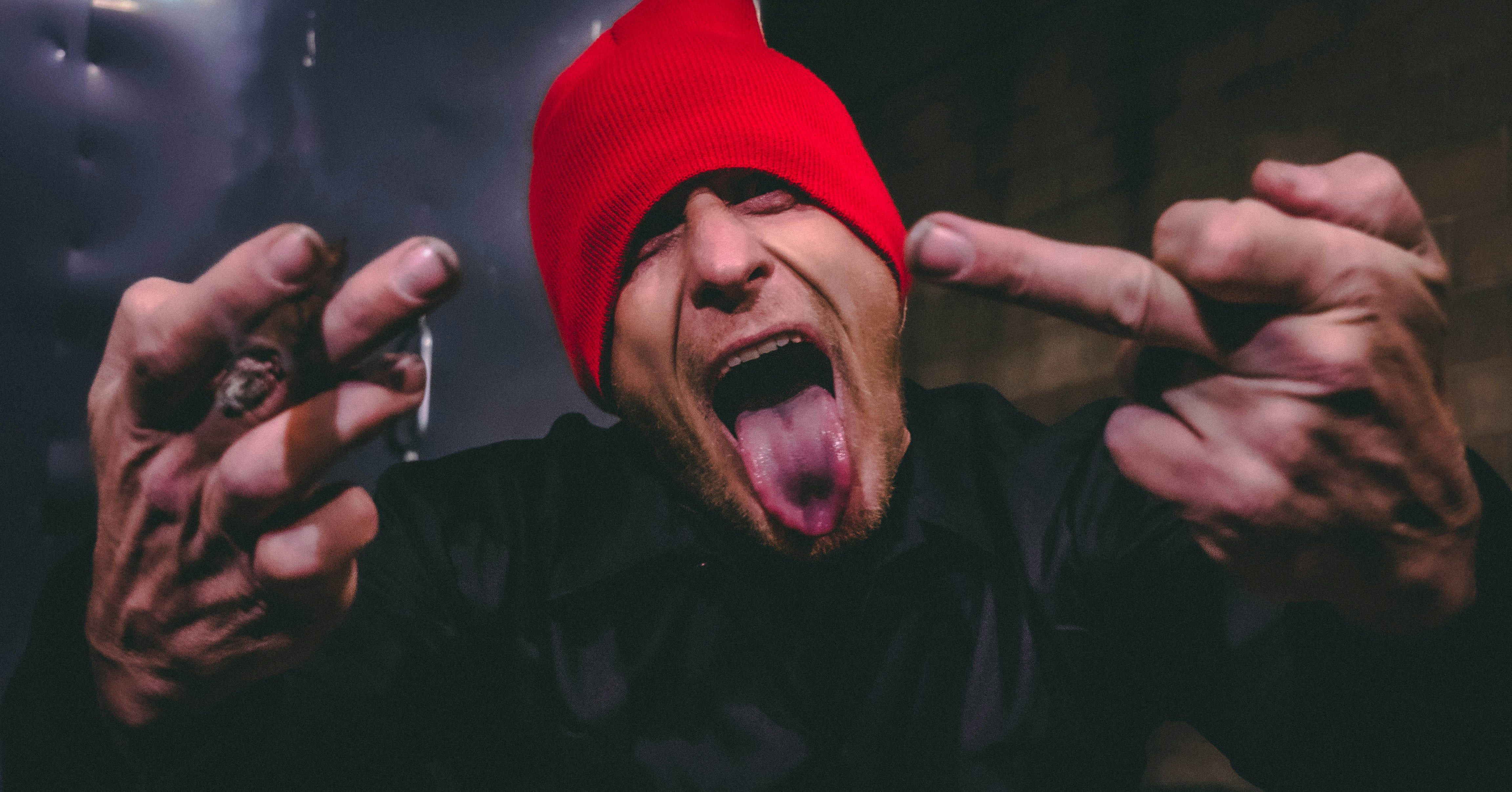 a man wearing a red hat and holding his hands up