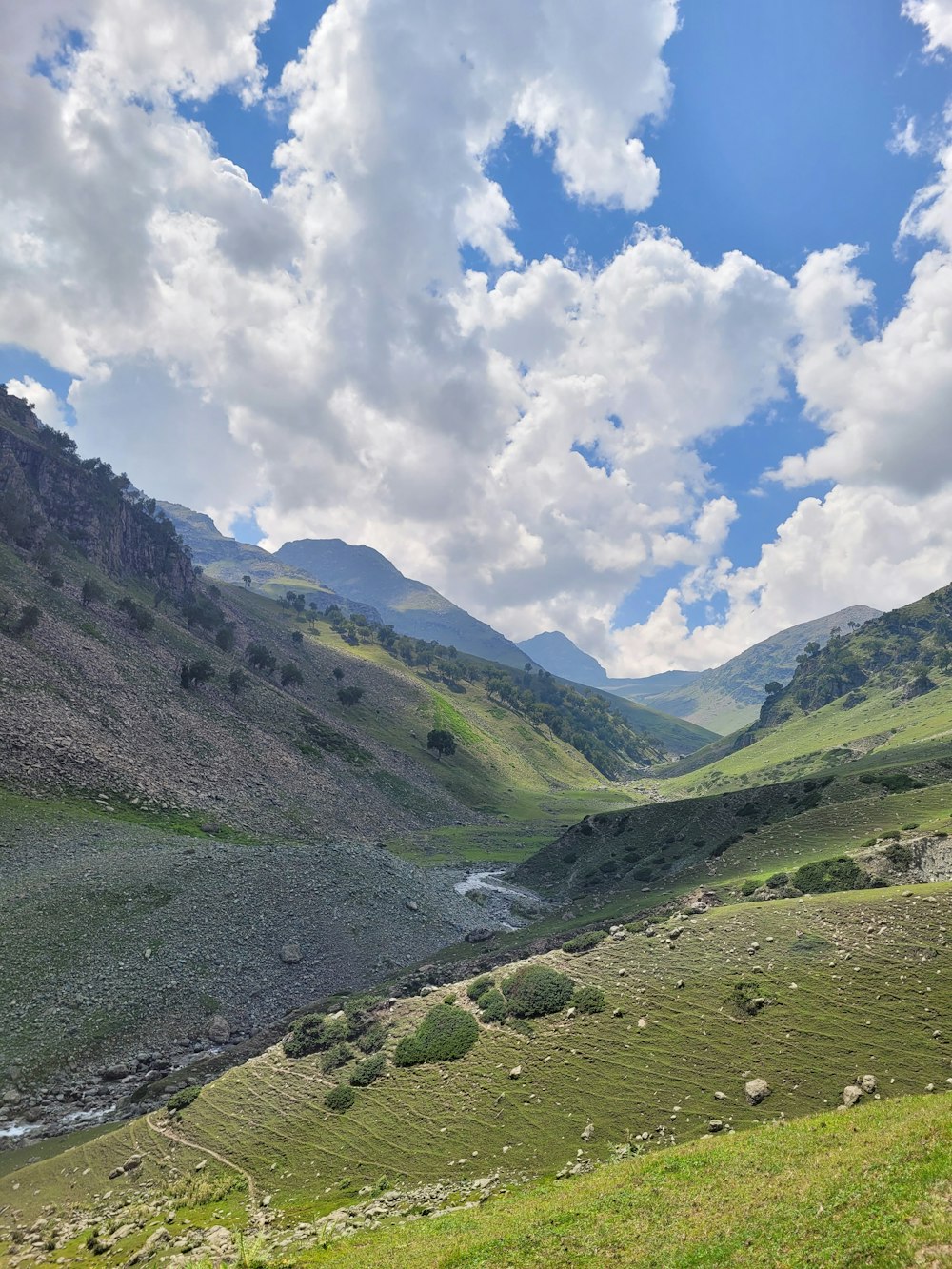 a valley with mountains and clouds