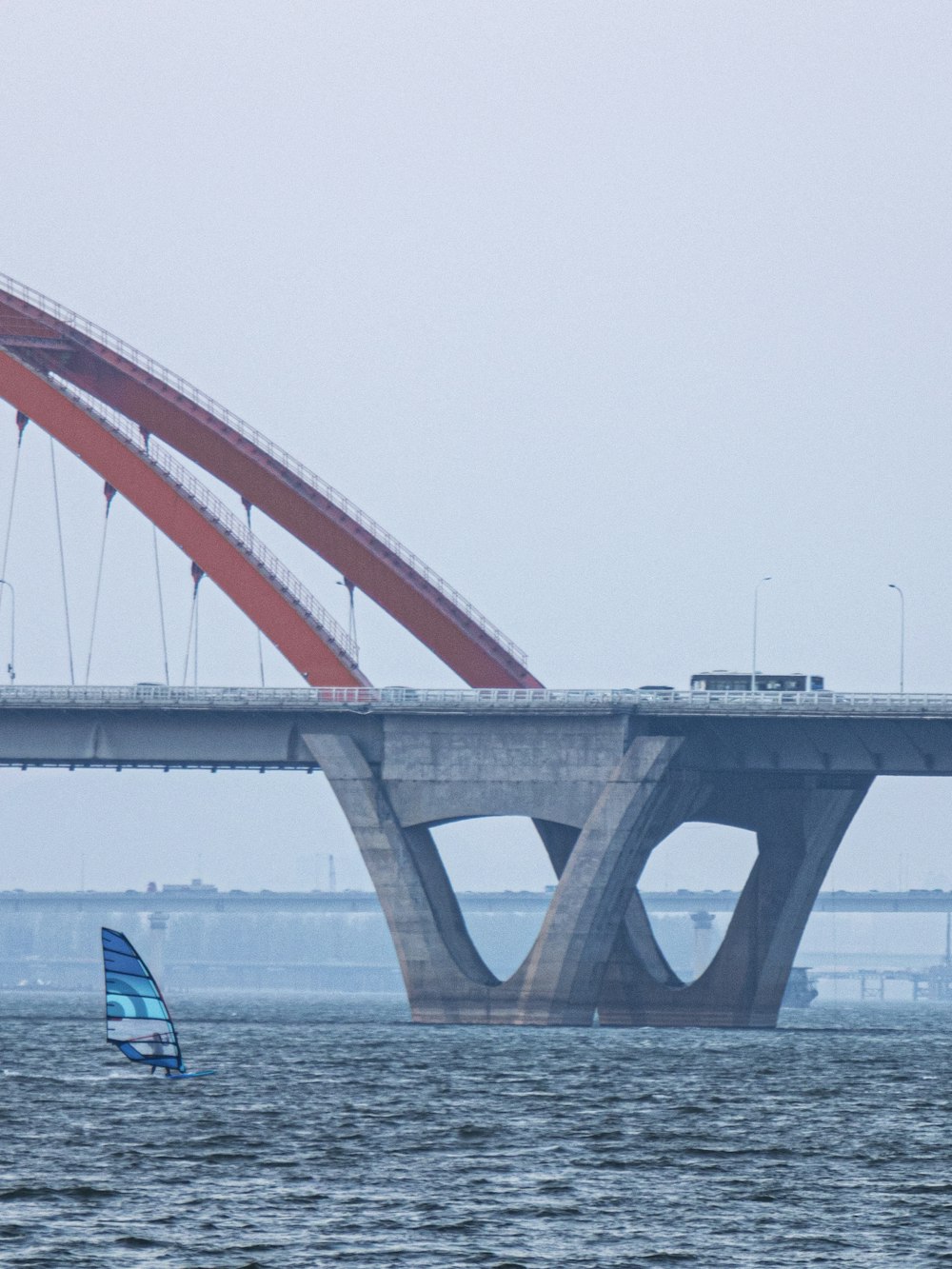 a sailboat in front of a bridge