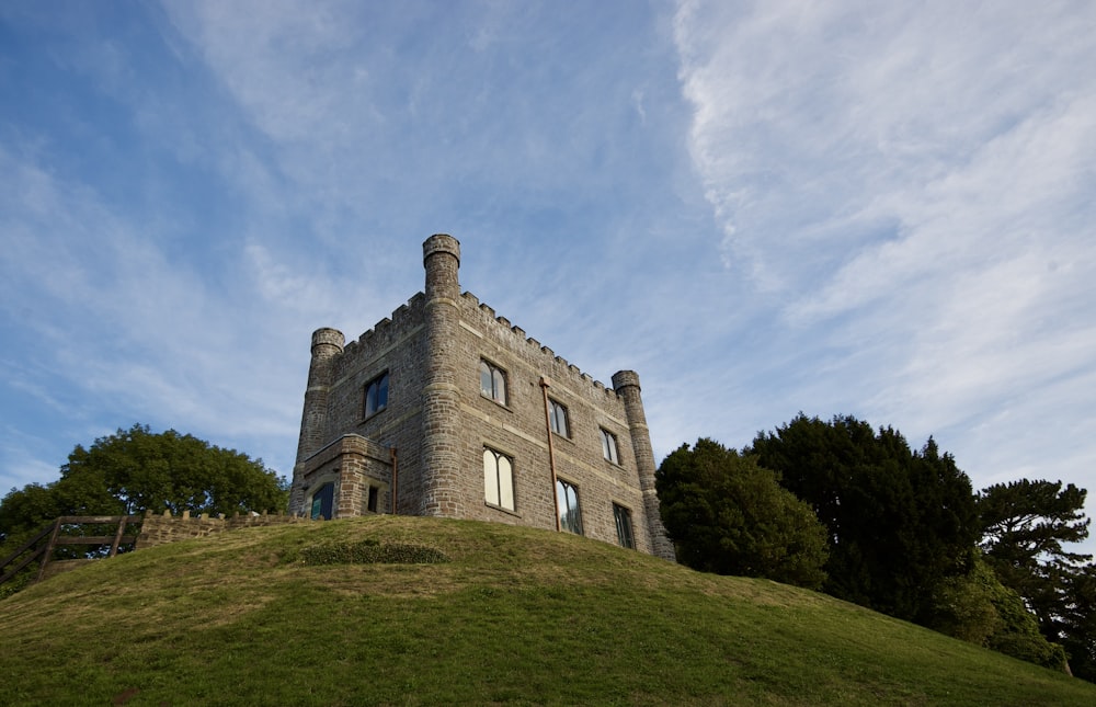 a stone building on a grassy hill