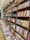 Rows of books neatly arranged on wooden shelves, featuring sections labeled nonfiction and classics. A long table displays various books lying flat, showcasing their covers.