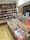 A bookstore with neatly arranged books on wooden shelves and several tables. The shelves are labeled with categories such as classics and fiction. Brightly colored book covers add a vibrant touch to the scene.