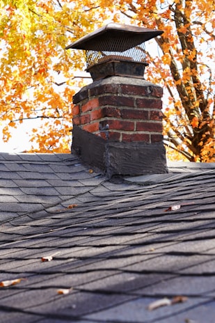 A completed chimney inspection report in front of a well-maintained residential chimney.