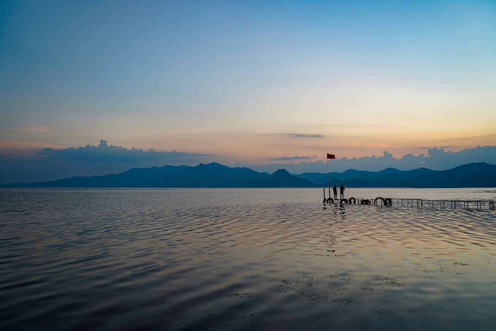 a body of water with a dock and a flag on it