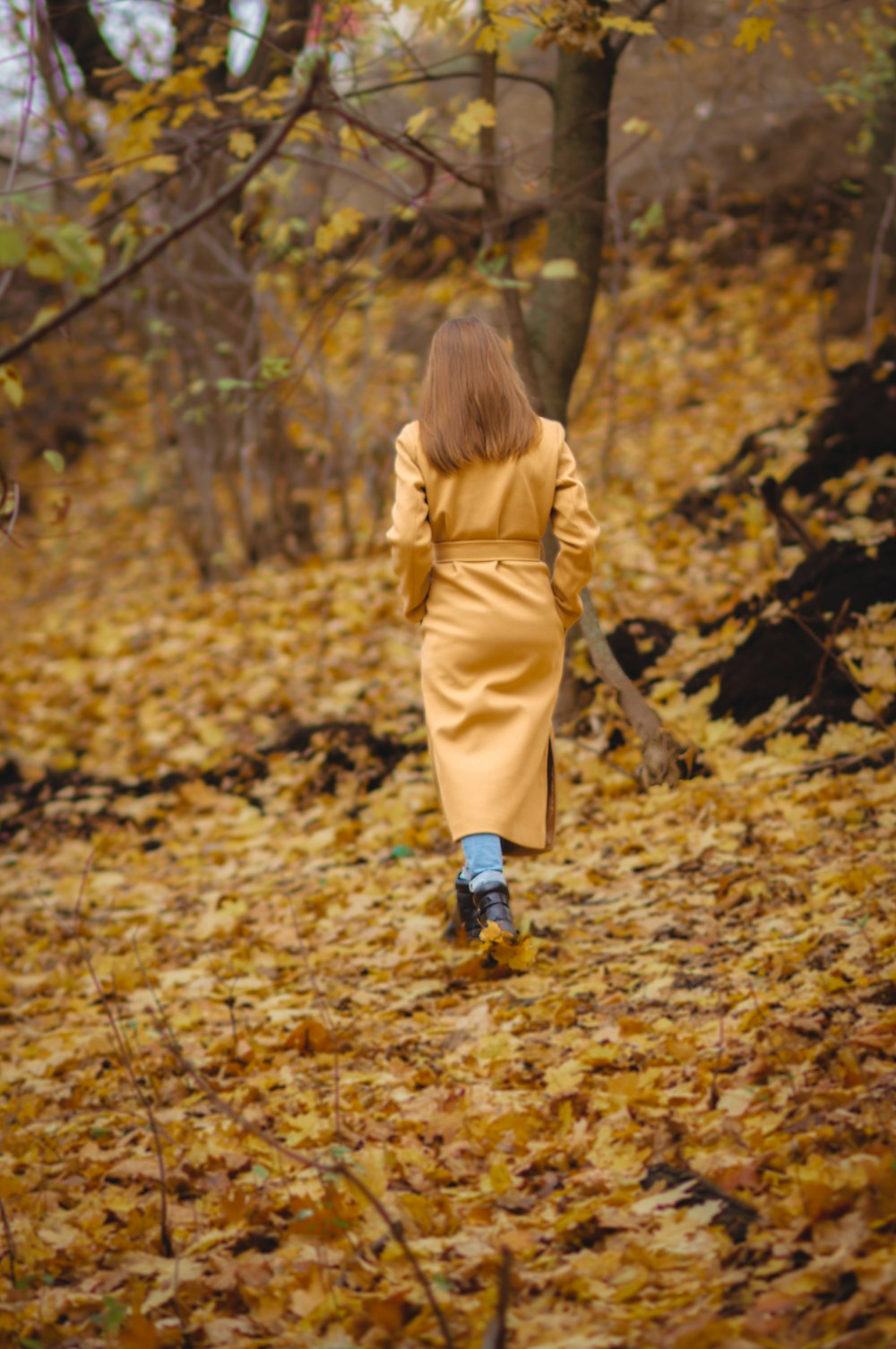 a girl walking through leaves