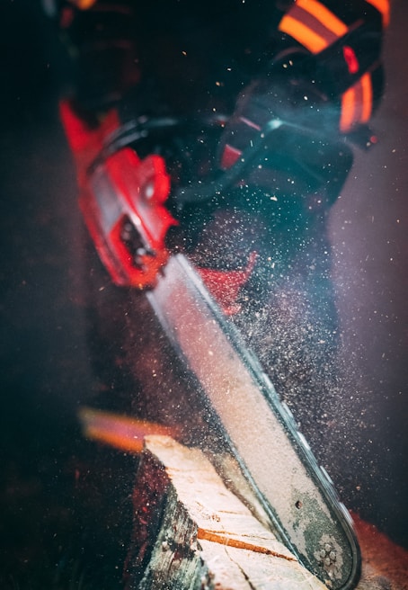 Close-up of a chainsaw cutting through a thick tree trunk during an emergency service call.