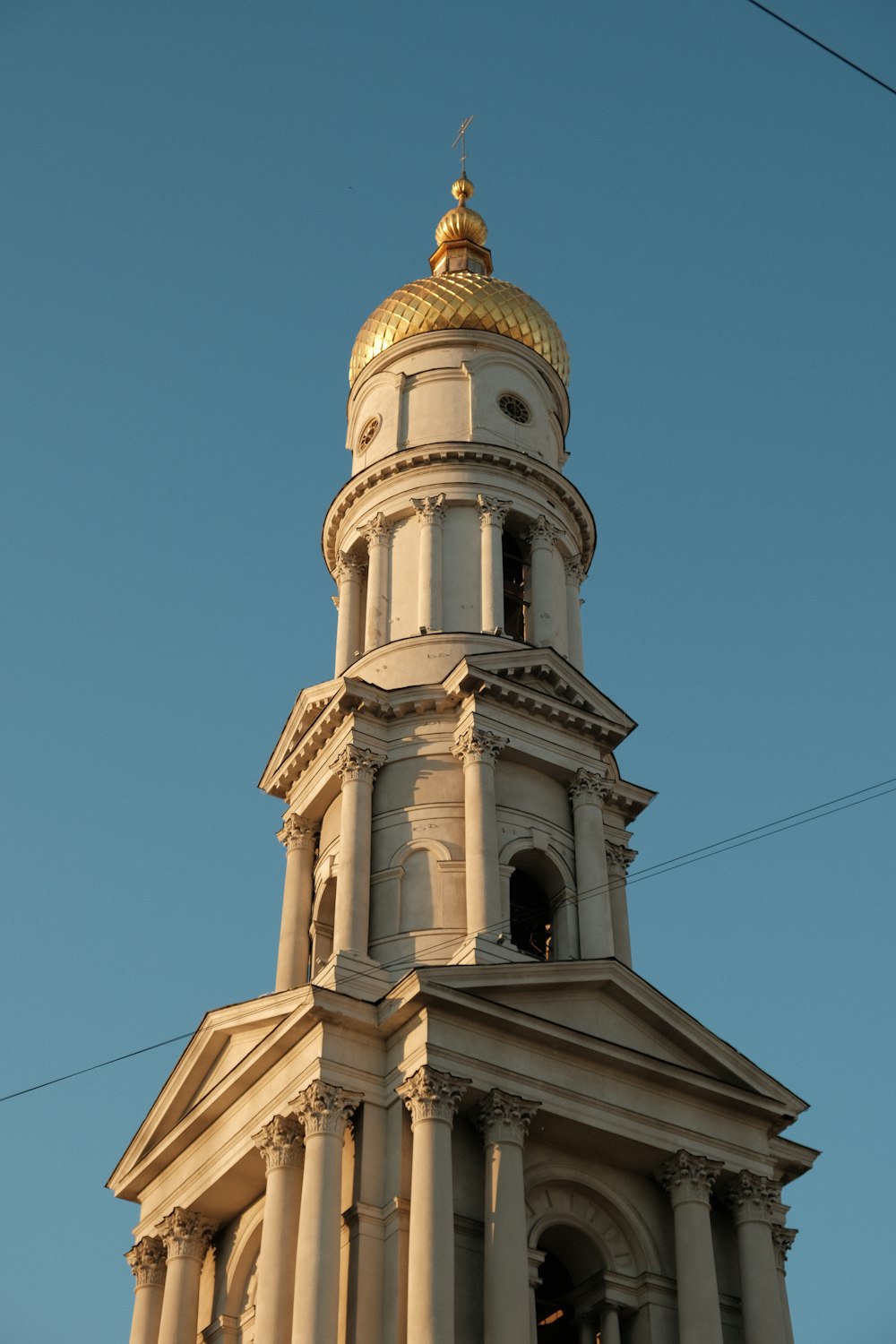 Un edificio alto blanco con un techo abovedado dorado