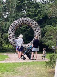 Volunteers collaborating on a garden sculpture made from natural materials.