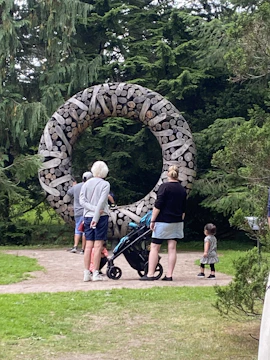 A community gathering outdoors surrounded by nature-inspired artworks.