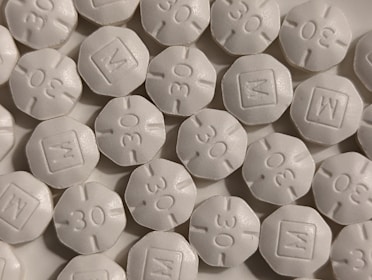 A close-up of assorted pain relief tablets on a white background.